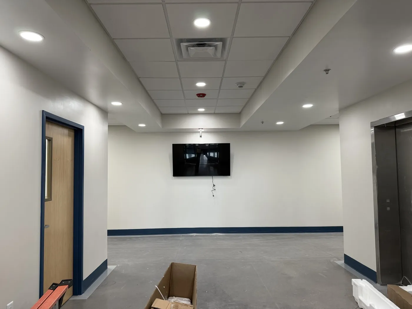 Wall-mounted screen in a school corridor