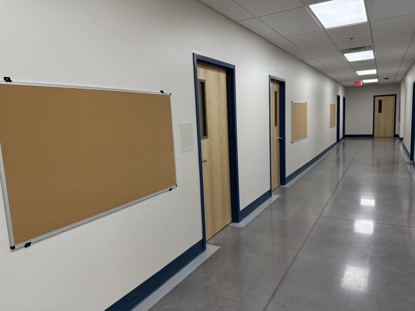 Wall-mounted bulletin boards along a school corridor